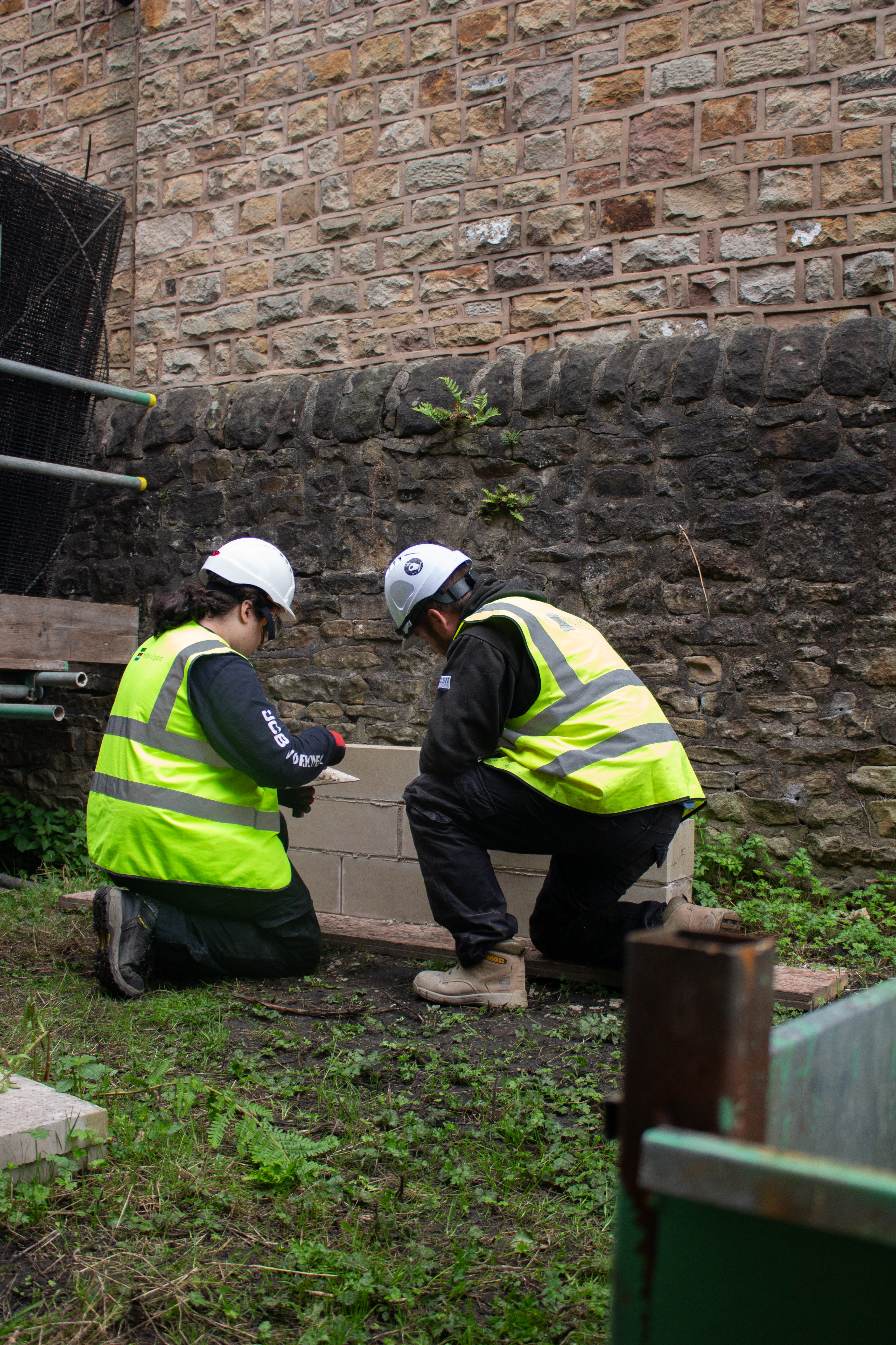 Apprentice being taught how to apply lime mortar.